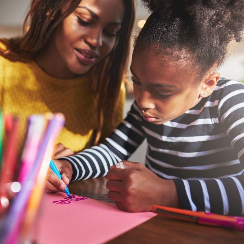 Young child receiving supervision while coloring